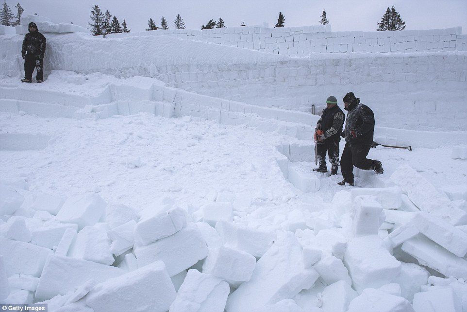 Workers seen breaking the oversized ice cubes during the construction process 